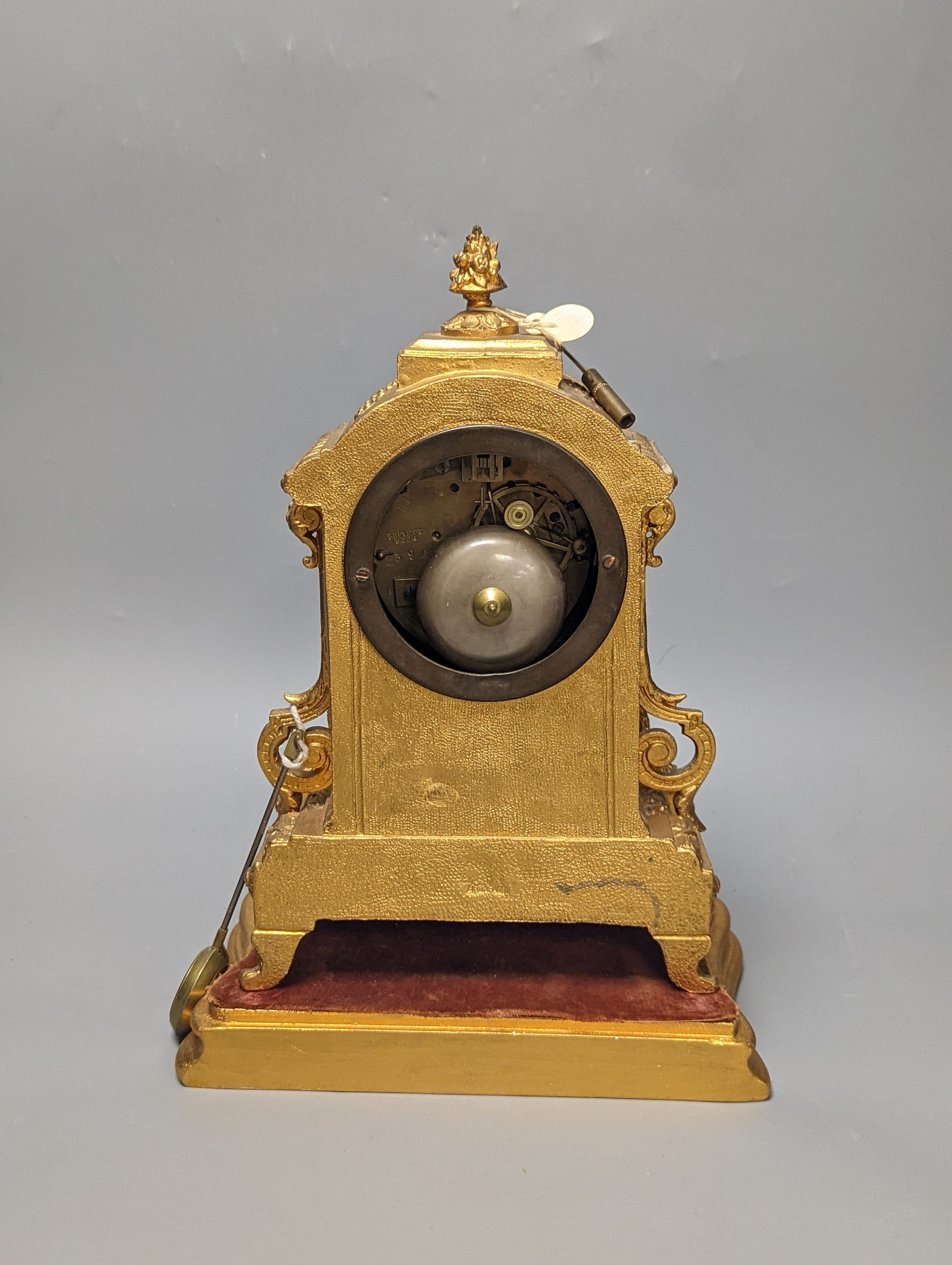 A 19th century gilt metal mantel clock on plinth with key and pendulum 30cm